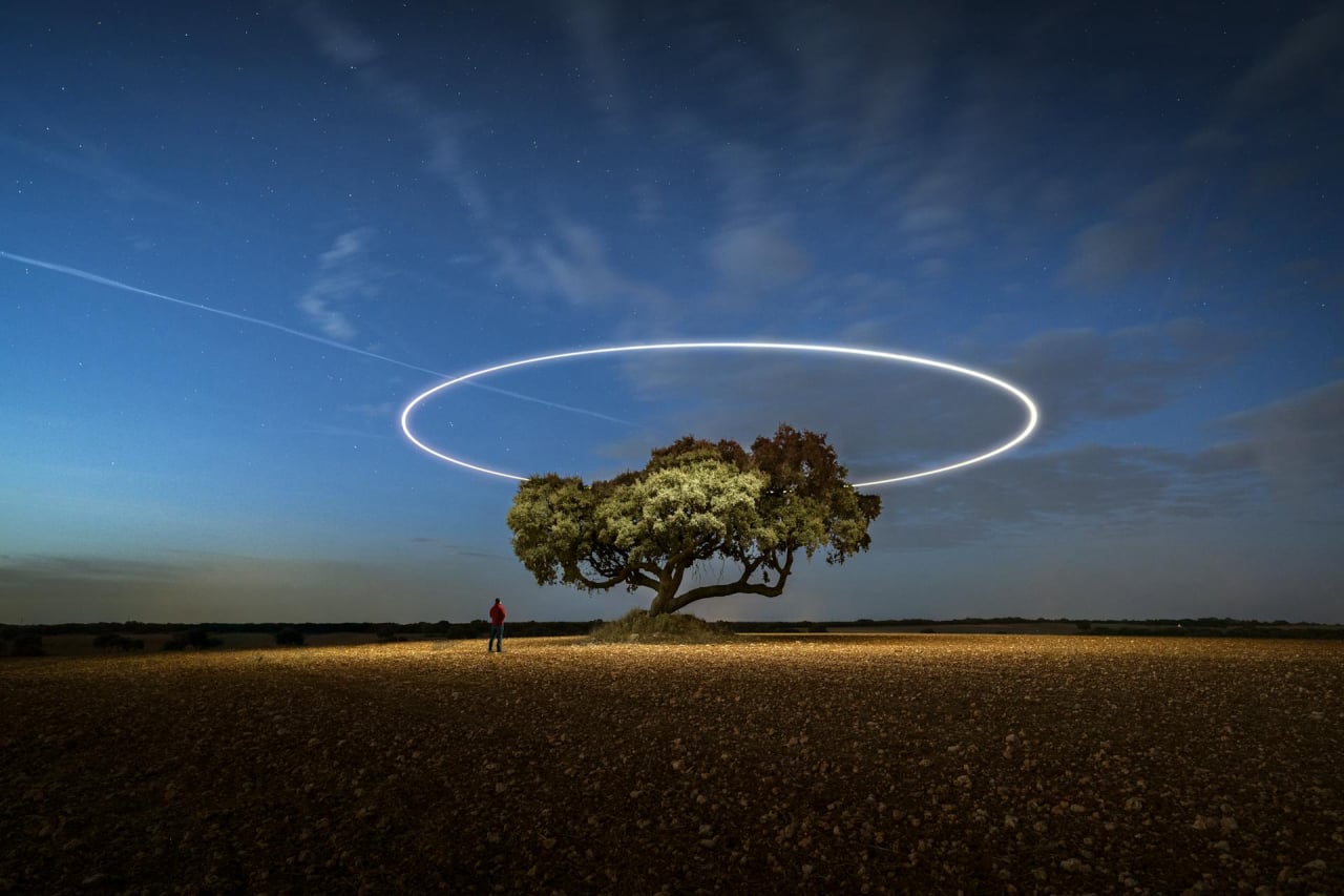Man Standing At Tree With Halo Ring Above It
