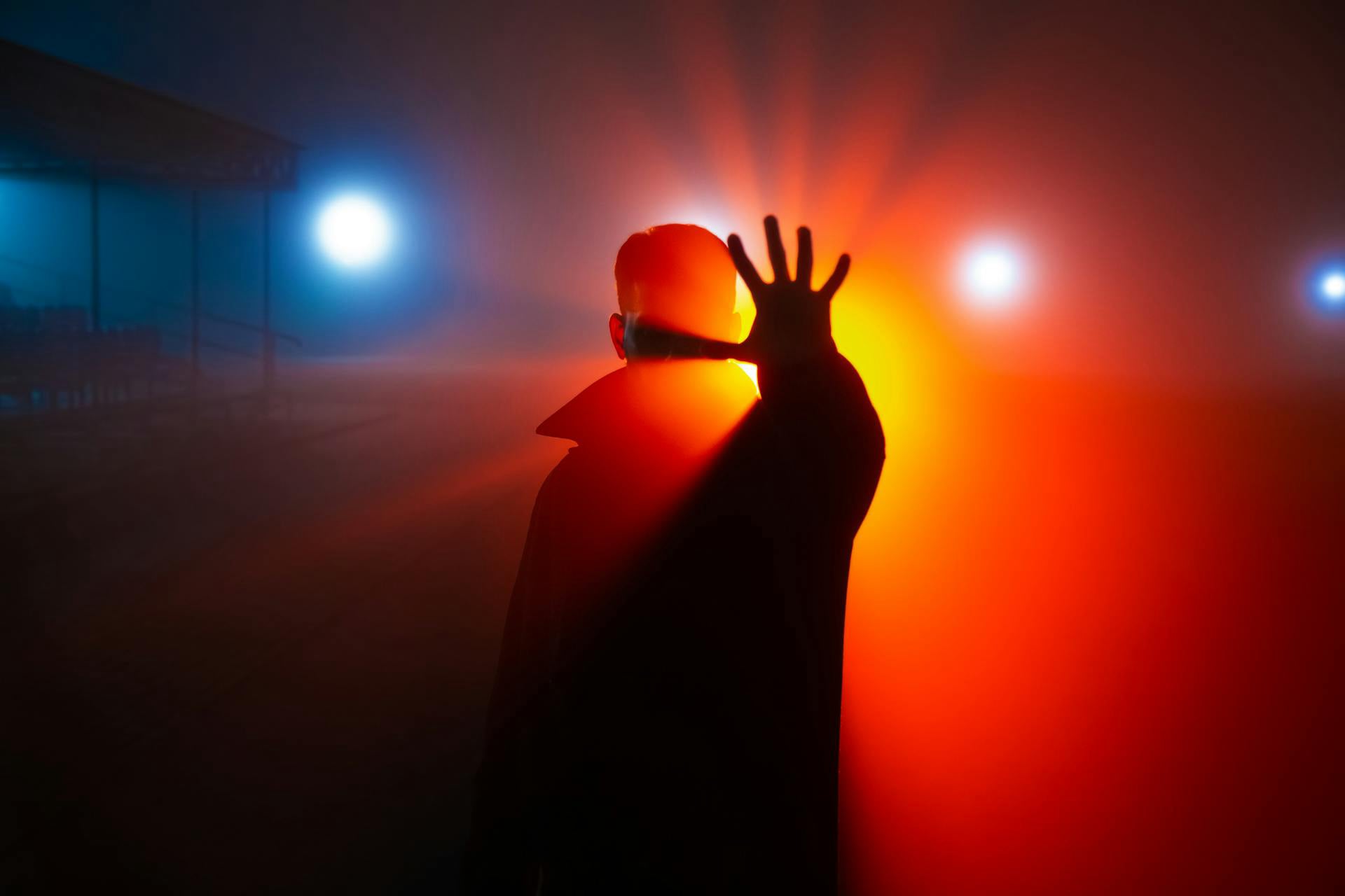 Man Holding Hand Up In Bright Orangish Light